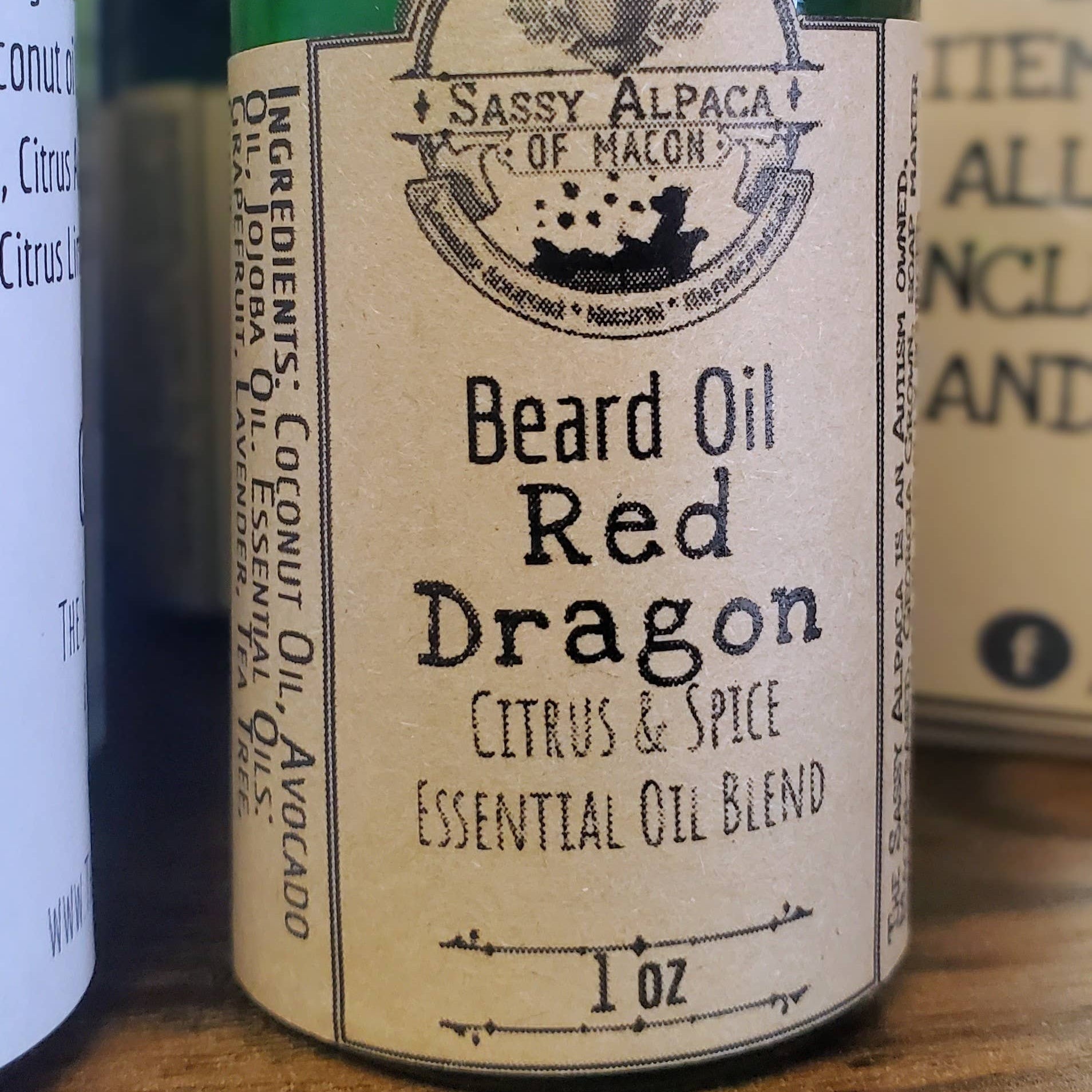 Bottle of 'Red Dragon' beard oil with a gold cap on a wooden surface.