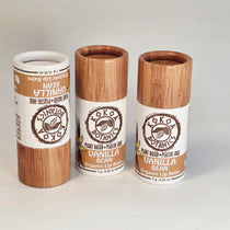 Three lip balm containers with wooden and paper design on a white background