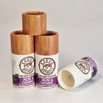 Three lip balm containers with wooden tops and white labels on a gray background