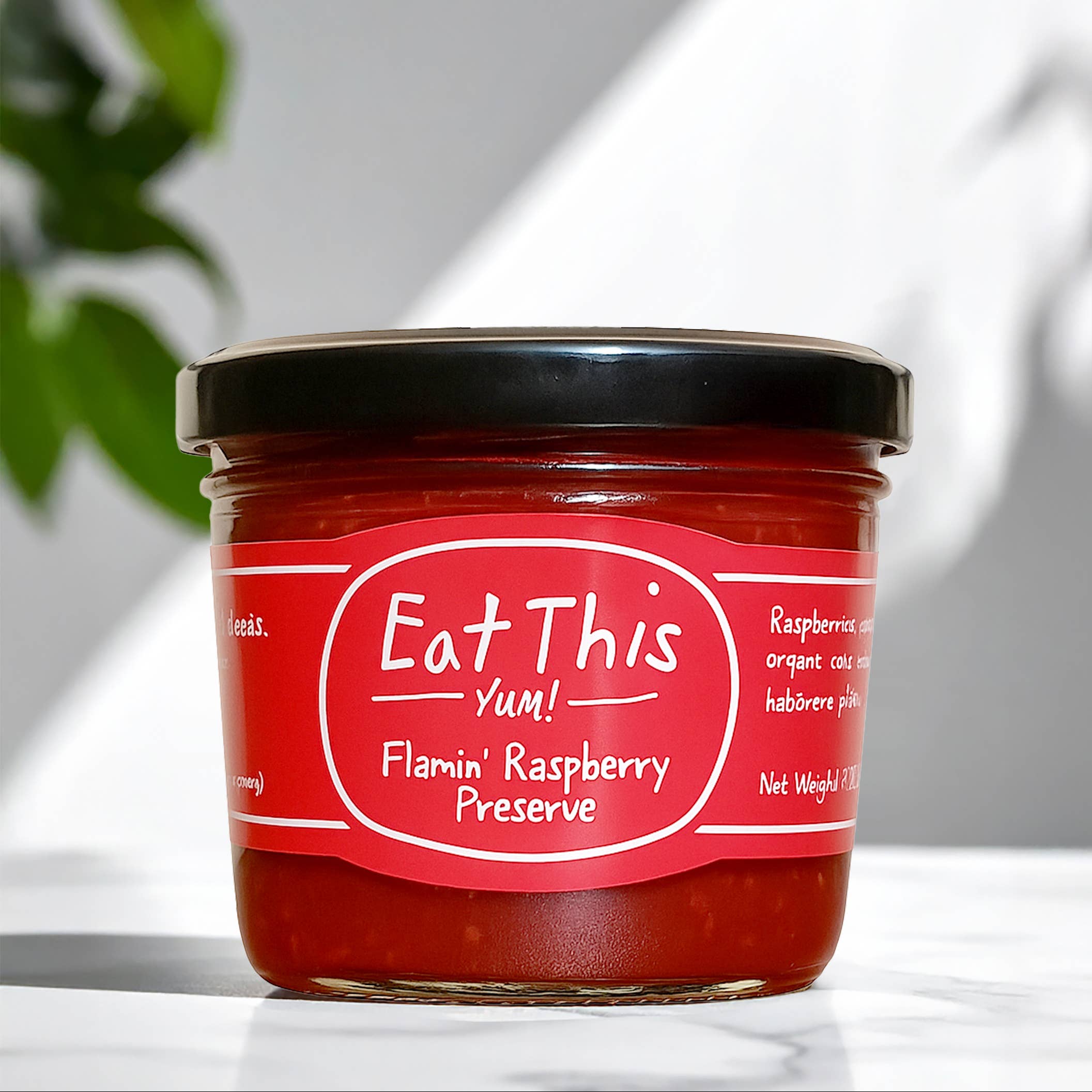 Jar of Flamin' Raspberry Preserve with a red label on a white surface.