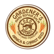 A round container label for Gardener's Hand Repair Balm with the brand Kokoa Botanics, featuring carrot seeds and the scent marked as Arnica & Carrot Seed.