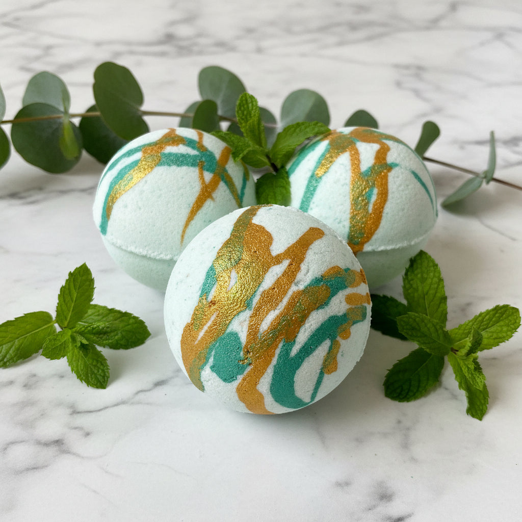 Three bath bombs with green and gold streaks on a wooden surface.