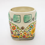 Ceramic mug with a colorful design of a van and flowers on a white background