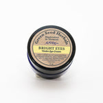 green seed herbals under eye balm in a small blue glass jar