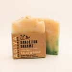 Bar of soap with a cardboard packaging labeled 'Dandelion Dreams' on a beige background