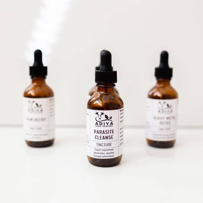 Three bottles of Adiya Parasite Cleanse tincture on a white background