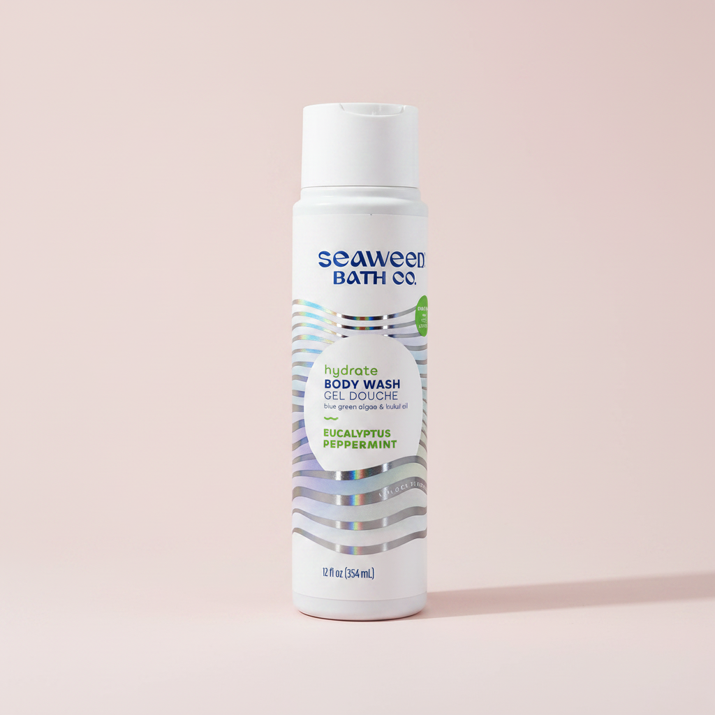 A white bottle of Seaweed Bath Co. Hydrate Body Wash in Eucalyptus Peppermint, standing upright on a light pink background.