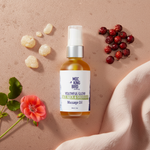 Frankincense & Rosehip Youthful Glow Massage Oil flat lay on rose gold surface with frankincense resin and rosehips