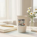Self-empowerment vinyl sticker on a ceramic travel mug with journal and flowers nearby