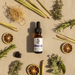 Catharsis Essential Oil Blend – flat lay on warm sand linen with vetiver, lemongrass, rosemary and labdanum