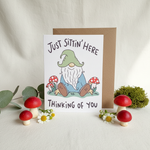 Gnome and mushroom thinking of you card with real mushrooms, eucalyptus and wildflowers on soft white surface