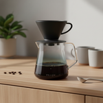 Fellow Mighty Small smoke grey glass carafe with Stagg pour over dripper on wood surface