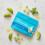 Hydrafuel Performance Gummies – Sour Patch Margarita lifestyle flat lay with lime wedges and fresh mint on white marble