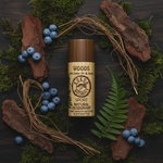 Woods magnesium deodorant flat lay on mossy wood with cedar bark, juniper berries and vetiver root