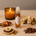 Adia Three Layers Fragrance Oil styled with amber candle, layered botanicals on cream linen
