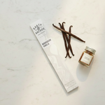 Madagascar Vanilla incense lifestyle flat lay with vanilla beans and extract jar on white marble
