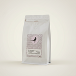 Apothecary Beans El Salvador white coffee bag on warm off-white background, clean studio hero shot