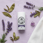 Lavender & Tea Tree magnesium deodorant flat lay on lavender linen with lavender sprigs and amethyst crystal