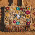 Roller skates Just Roll With It patch on tattered boho denim bag with embroidered flowers and fringe