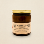 Bourbon Apple soy candle in amber apothecary jar on warm cream linen background with shadow