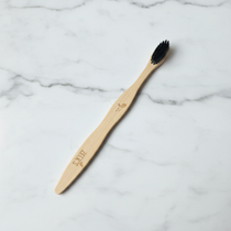 Bamboo charcoal toothbrush studio shot on white marble background