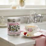 Women's Tonic Herbal Tisane tin beside floral porcelain teacup and saucer with chamomile flower and strawberry on vanity shelf