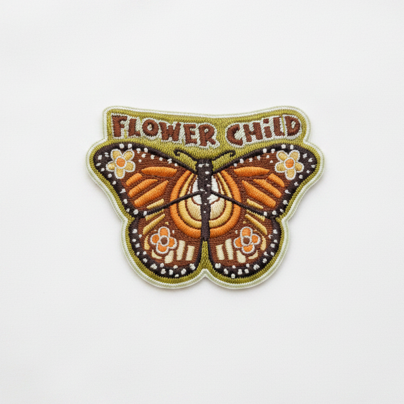 Flower Child monarch butterfly embroidered iron-on patch on clean white surface