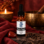 Black Pepper Essential Oil in a burgundy and stone meditation setting.
