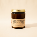 Hawaiian Dream soy candle in amber apothecary jar on warm cream linen background with shadow