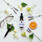 Focus Essential Oil Blend – eclectic editorial on white marble with lavender, osmanthus, reading glasses and fountain pen