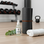 Unscented Magnesium Oil Spray – beside rolled yoga mat with eucalyptus and gym equipment in background