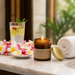 Hawaiian Dream candle on resort spa vanity with plumeria lei, tropical flowers and white towel