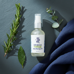 Wintergreen & Rosemary Sore Muscles Massage Oil flat lay on slate with rosemary, wintergreen and eucalyptus