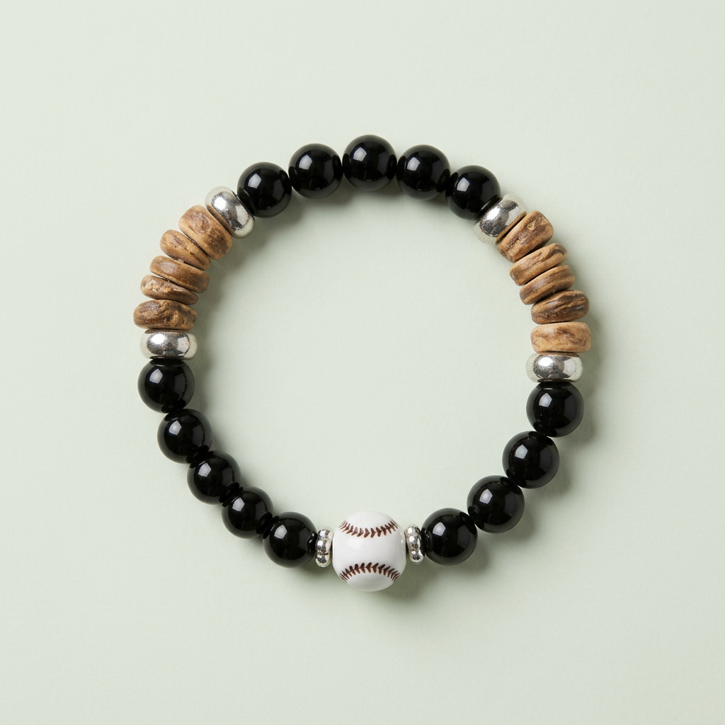 Black beaded baseball bracelet with white baseball accents and tan chip details on a pale sage background