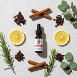 Bandits Essential Oil Blend – flat lay with cloves, cinnamon, lemon and eucalyptus on white linen