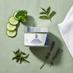 Daily Greens Superfood Cream flat lay on sage linen with broccoli, cucumber and green tea leaves