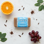 Bogüe Milk Soap No.30 Grapeseed Exfoliating – lifestyle flat lay with orange, grapes, eucalyptus and clove
