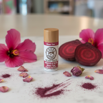 Kokoa Botanics Hibiscus & Beets Lip Balm styled with hibiscus flowers, beet root, and rose petals on marble