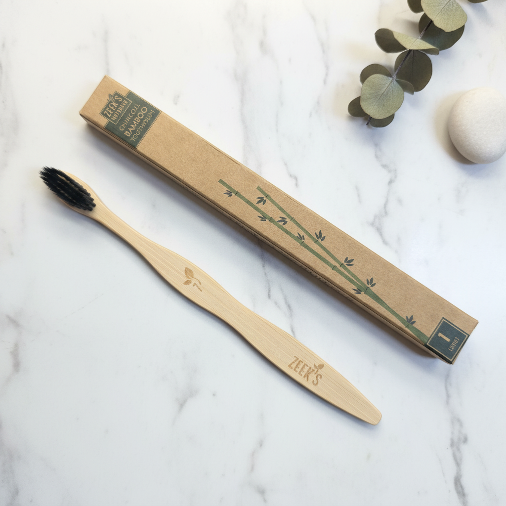 Bamboo charcoal toothbrush with kraft paper eco packaging flat lay on marble