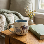 Reverse farm animal artwork on the artisan mug in a cozy reading nook