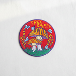 Free Spirit mushroom embroidered patch on clean white surface