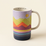 Colorful mountain landscape latte mug with cream handle and This Must Be the Place inner rim message on an ivory background