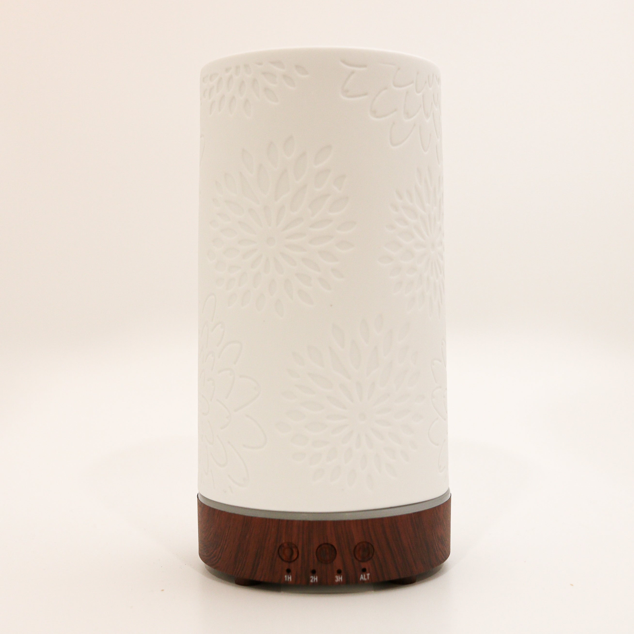 ceramic diffuser with dark wood base with light and time settings on white background 