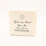 rosemary mint green tea shampoo bar wrapped in seed paper on white background