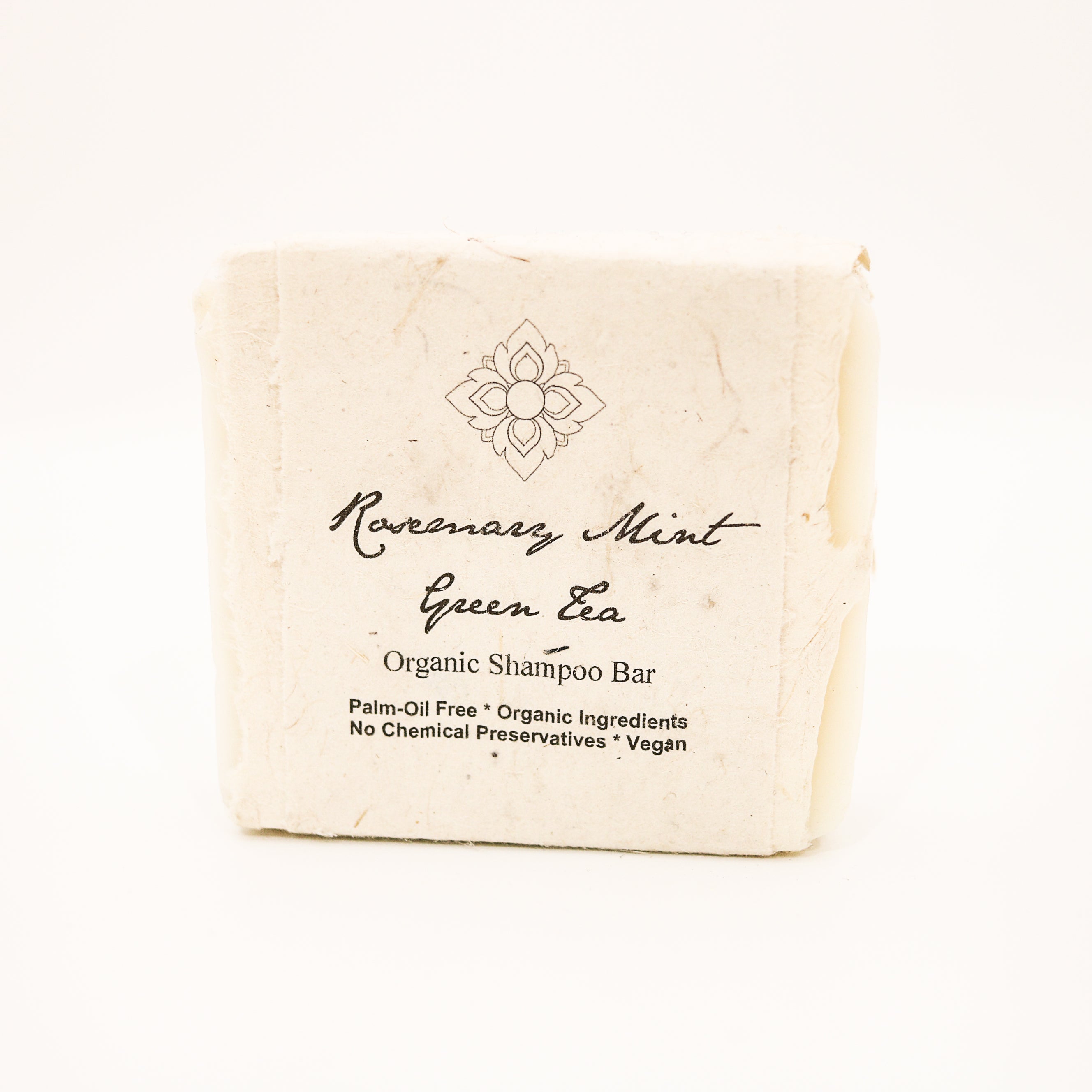 rosemary mint green tea shampoo bar wrapped in seed paper on white background