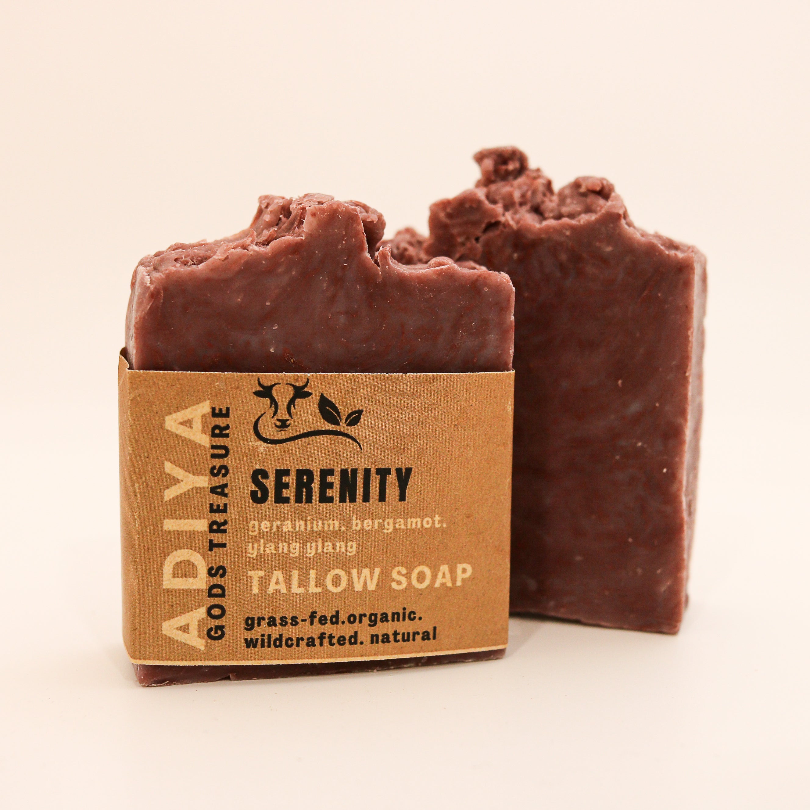 Two bars of tallow soap with a brown cardboard box labeled 'Serenity' on a beige background.