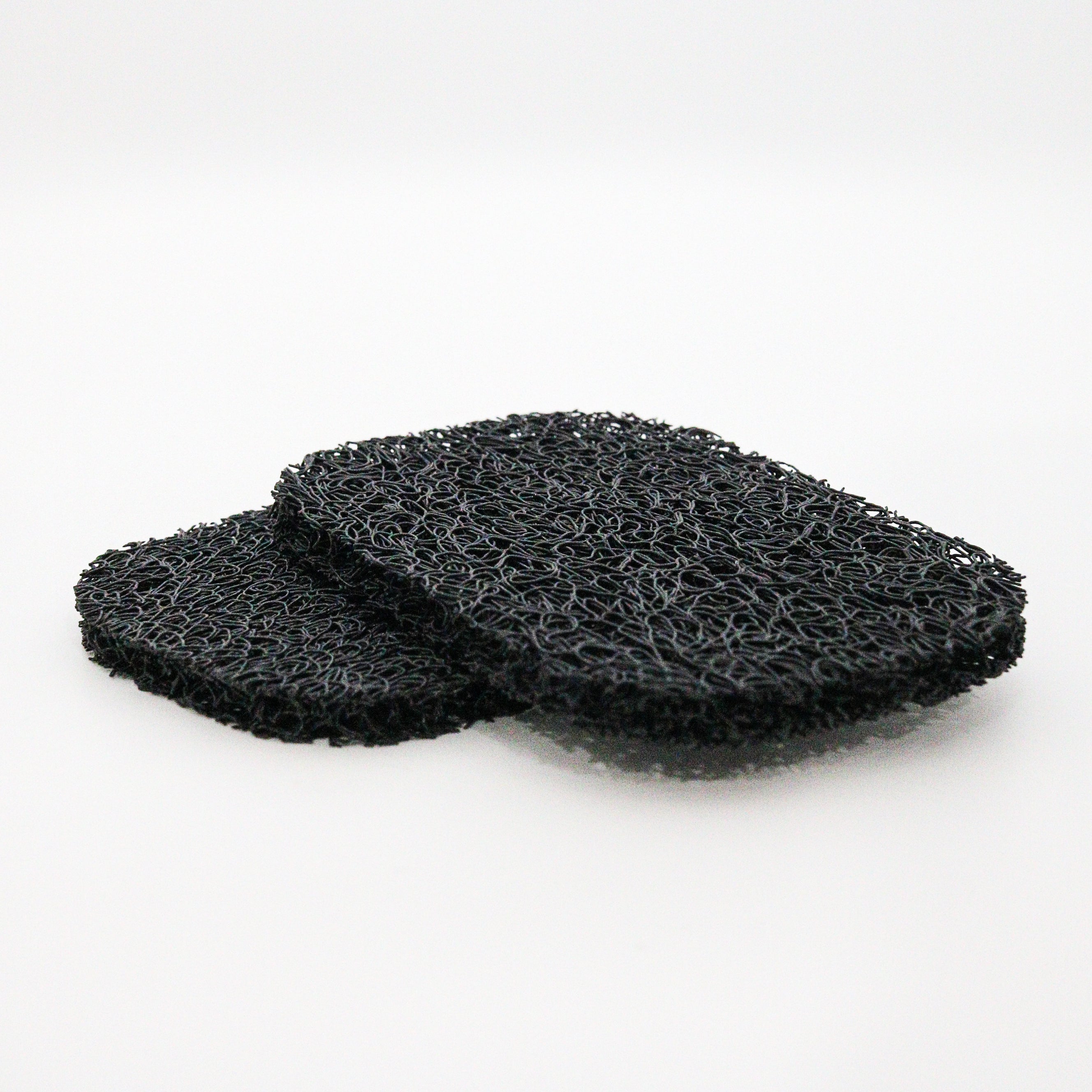Two black soap lift pads on a white background