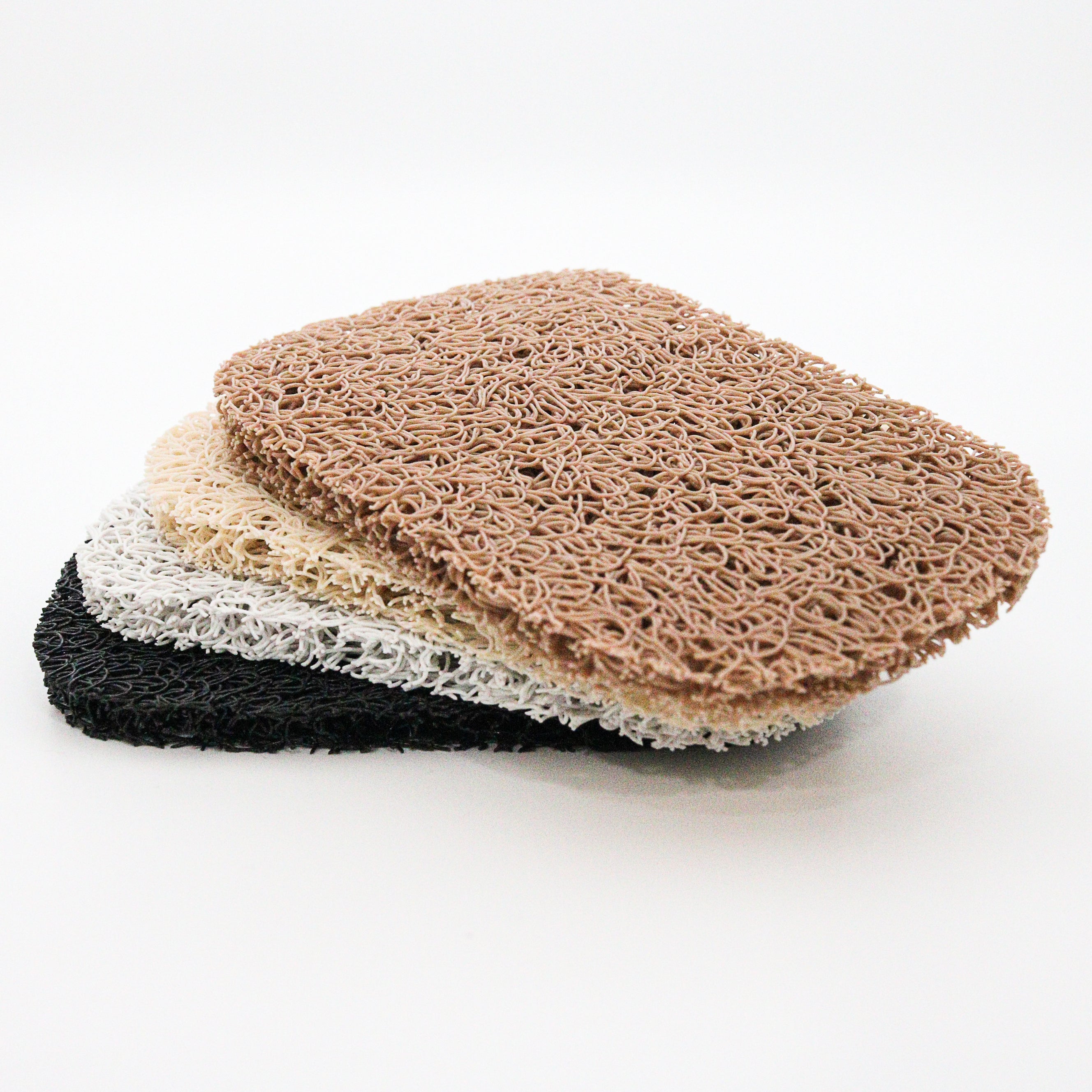 Four mesh soap lift pads in black, shite, beige, and brown on a white background