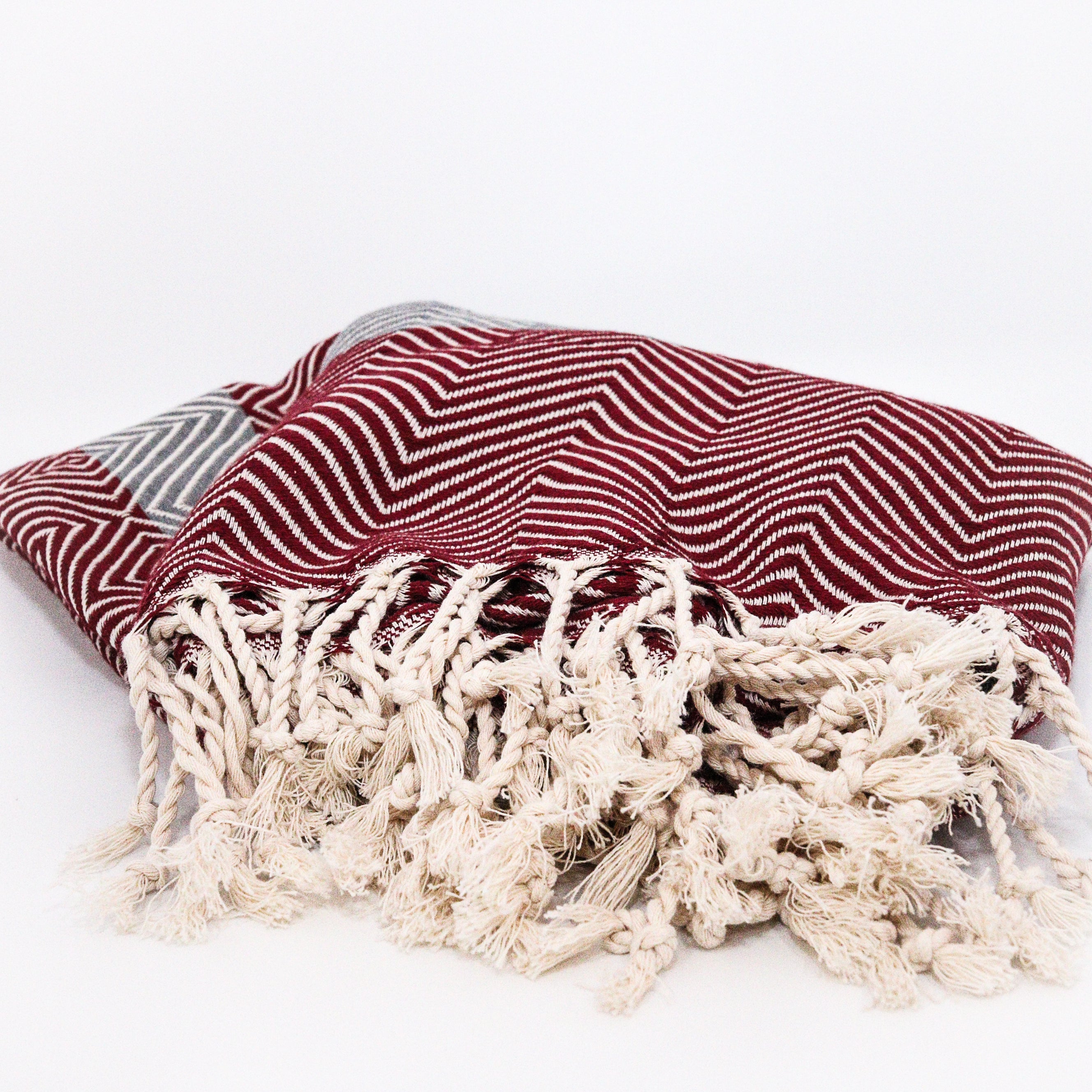 red grey pattern organic cotton Turkish towel with cream tassel on a grey background