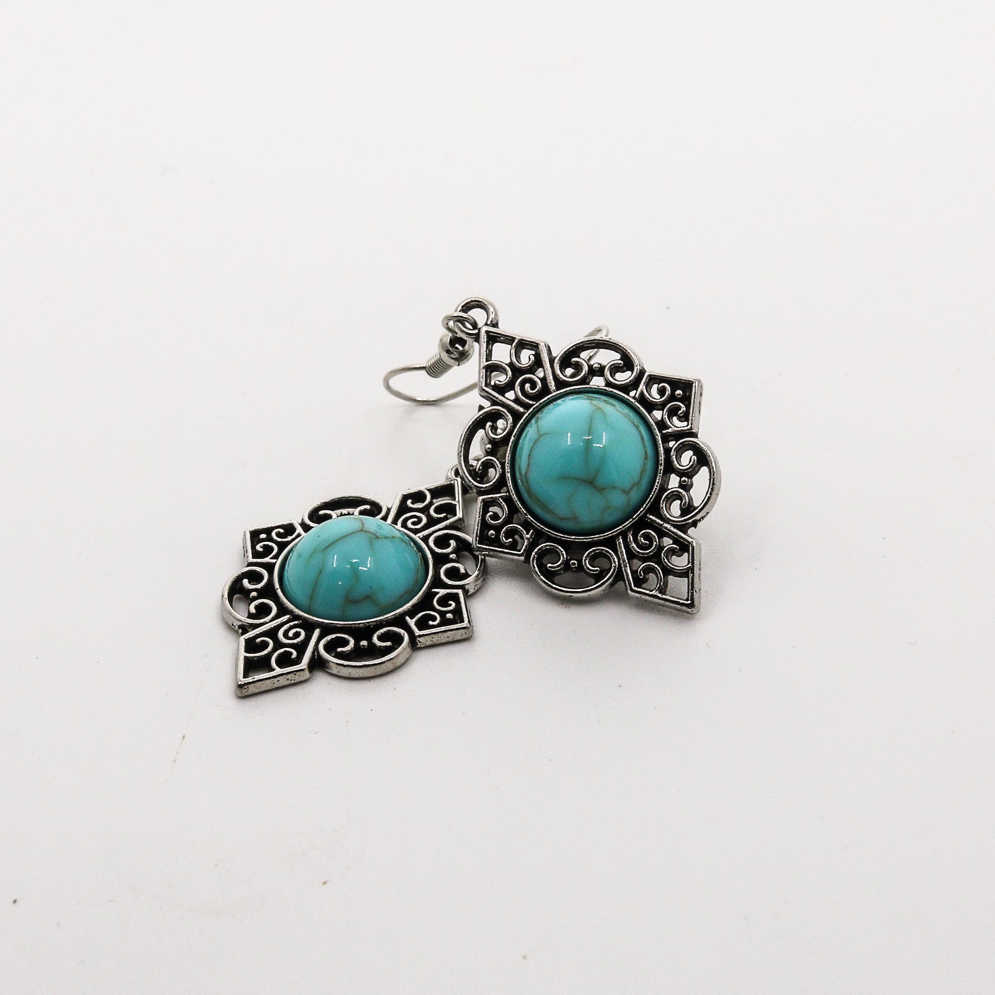 Pair of earrings with turquoise stones on a white background